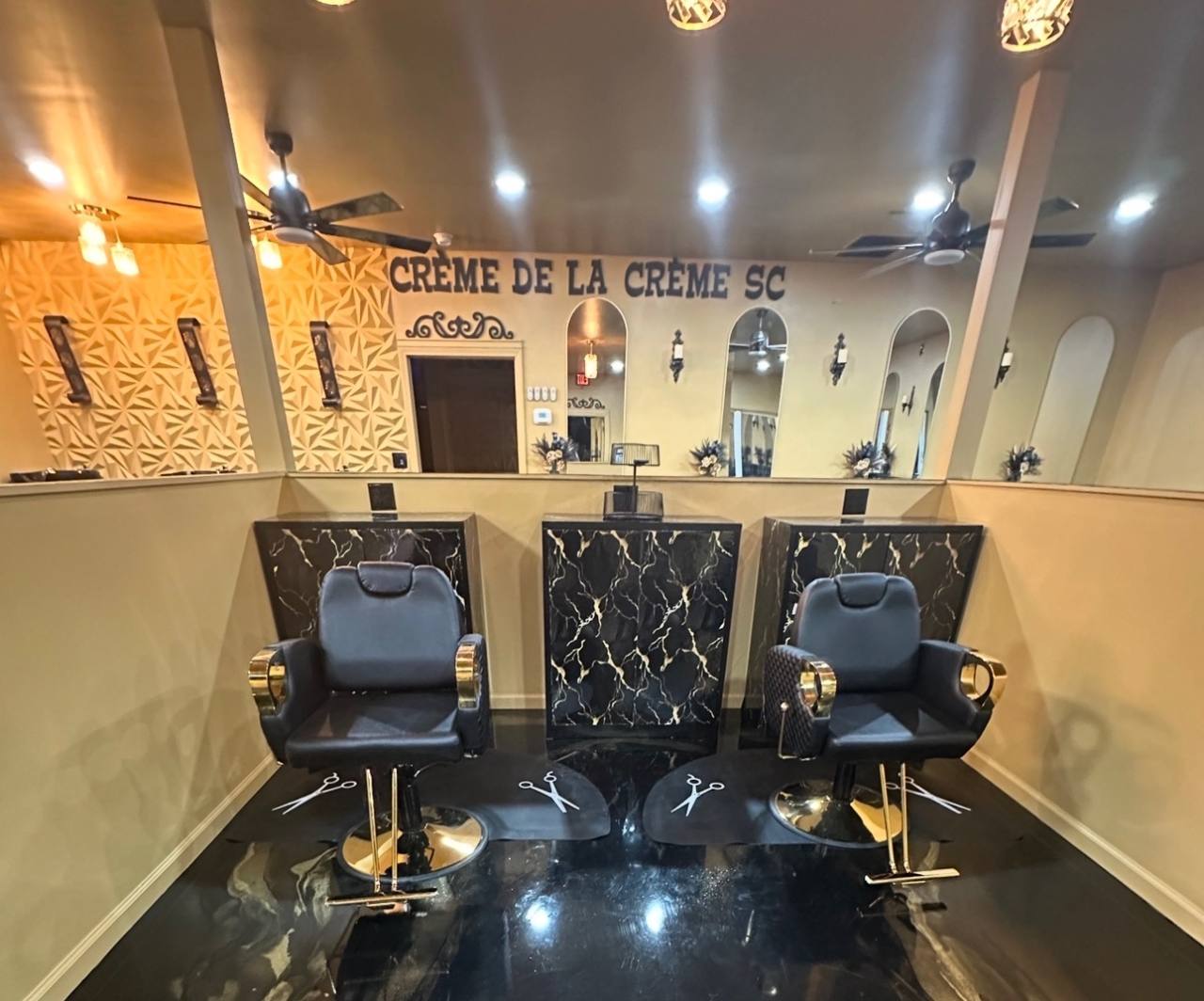The actual salon styling chairs and black marble stations with gold details